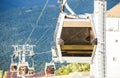 Photo of cable car cabins against backdrop of mountain slope