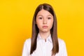 Photo of calm focused serious cute schoolgirl look camera wear white shirt isolated yellow color background