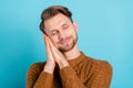 Photo of calm peaceful sleepy young man hold hands head nap rest relax isolated on blue color background