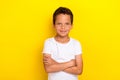 Photo of calm serious school boy dressed trendy white clothes outfit arm crossed isolated on yellow color background Royalty Free Stock Photo