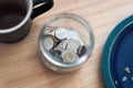 Canadian toonie loonie and quarter money in jar on a desk Royalty Free Stock Photo