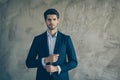 Photo of candid smart clever reliable man fastening cufflinks at his sleeves staring at you grey color