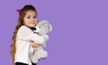 In the photo, it is captured how a little girl plays with her favorite toy, that is, a gray teddy bear, she is very Royalty Free Stock Photo