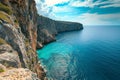 The photo captures a breathtaking view of the ocean as seen from the edge of a towering cliff, A soaring view of a vibrant sea and