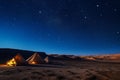 A photo capturing a couple of tents placed in the center of a vast desert landscape, Sweeping desert landscape dotted with nomadic