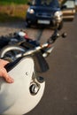 Photo of car, helmet in the hand of a man and motorcycle on the road, the concept of road accidents Royalty Free Stock Photo