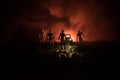 photo of a car stopped on the road lighting up a zombies. Silhouette terrible zombie night near the car. Miniature decoration