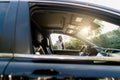 Photo of the car window on sunny day and successful African businessman walking while taking at the phone on the Royalty Free Stock Photo