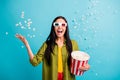 Photo of carefree girl hold bucket popcorn throw food open mouth wear 3d glasses green shirt isolated blue color