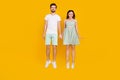 Photo of carefree inspired dream spouses couple jump hold hands wear casual outfit isolated yellow color background