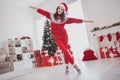 Photo of carefree inspired lady hands wings plane pose wear santa hat sweater pants socks in decorated home indoors