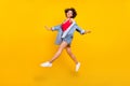 Photo of carefree inspired lady jump enjoy flight wear denim jacket mini skirt shoes isolated yellow color background