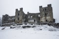 A photo of a castle covered in snow, situated on top of a hill, An ancie