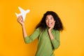 Photo of casual mixed-race positive pretty girlfriend smiling toothily air plane with hand expressing positive emotions Royalty Free Stock Photo