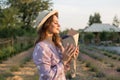 Photo of caucasian young woman in dress holding bouquet of flowers while walking outdoor through lavender field in summer Royalty Free Stock Photo