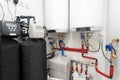 Photo of central hydraulic boiler in light bright room with red pipes heating element and smart control panel