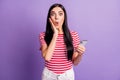 Photo of charming amazed lady hold phone hand cheek reaction post like on purple color background