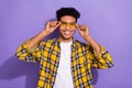 Photo of charming attractive guy dressed checkered yellow shirt arms dark eyewear isolated purple color background