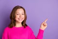 Photo of charming cheerful young girl point index finger empty space promoter isolated on purple color background Royalty Free Stock Photo