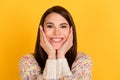 Photo of charming cheerful young woman hold hands cheekbones wear sweater isolated on yellow color background