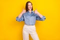 Photo of charming cheerful young woman hold hands show thumb up blink eye isolated on yellow color background Royalty Free Stock Photo