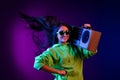 Photo of charming cheerful young woman hold shoulder boombox fly hair smile isolated on dark gradient background