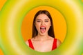 Photo of charming cool lady dressed bodysuit looking inside circle showing tongue yellow color background