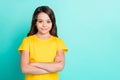 Photo of charming cute confident schoolgirl standing in front of camera creating copyspace while isolated with turquoise