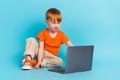 Photo of charming cute little boy sitting floor watching film cartoon online academic classes course isolated on cyan Royalty Free Stock Photo