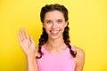 Photo of charming cute young woman pigtails wear tank top waving palm hello isolated yellow color background