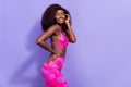 Photo of charming dreamy afro girl wear pint sexy outfit hand arm cheek cheekbone empty space smiling  purple Royalty Free Stock Photo