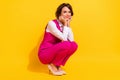 Photo of charming dreamy young woman dressed pink suit smiling sitting arms cheeks isolated yellow color background