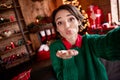 Photo of charming flirty young woman dressed green sweater recording self video sending you arm kiss indoors house home