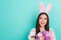 Photo of charming funky lady dressed striped pullover hare headband holding tulips empty space isolated teal color Royalty Free Stock Photo