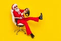 Photo of charming funky retired guy wear red tux claus hat sitting chair auto driver rider isolated yellow color Royalty Free Stock Photo