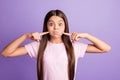 Photo of charming funny young girl wear pink t-shirt fingers pointing bloated cheeks isolated violet color background