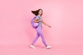 Photo of charming funny young woman dressed striped clothes rucksack walking wind blowing smiling isolated pink color