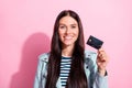Photo of charming happy young woman hold credit card good mood isolated on pastel pink color background Royalty Free Stock Photo