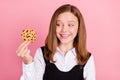 Photo of charming hungry school girl wear black white uniform ready eating tasty gingerbread isolated pink color
