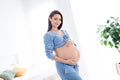 Photo of charming lovely tender gentle pregnant girl touching tummy waiting meet firstborn baby white light indoors