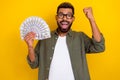 Photo of charming lucky guy dressed green shirt eyewear rising fist money fan isolated yellow color background Royalty Free Stock Photo