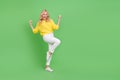 Photo of charming lucky woman wear yellow sweater rising fists empty space isolated green color background