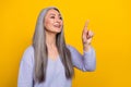 Photo of charming modern young pensioner lady using modern technology interface on yellow color background