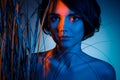 Photo of charming mysterious exotic short-haired woman hide jungle plant grass isolated blue neon light color background
