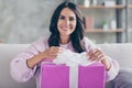 Photo of charming nice happy young woman open gift box celebrate birthday smile sit sofa indoors inside house Royalty Free Stock Photo