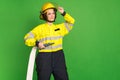 Photo of charming positive firewoman dressed yellow uniform arm hand helmet holding hose empty space isolated green