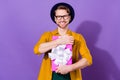 Photo of charming positive happy young man hold hands hug gift box isolated on purple color background Royalty Free Stock Photo