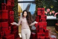 Photo of charming pretty amazed young asian girl standing among many red surprise boxes open mouth excited. Royalty Free Stock Photo