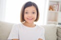 Photo of charming pretty school girl wear white t-shirt smiling sitting sofa indoors house home room