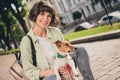 Photo of charming pretty young lady dressed green shirt backpack walking holding small friend smiling outdoors urban